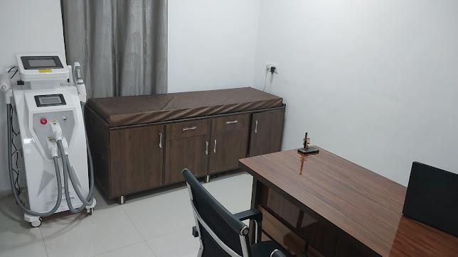 Consultation room at Aura Derma & Aesthetic Clinic with laser treatment machine, treatment bed and doctor's desk